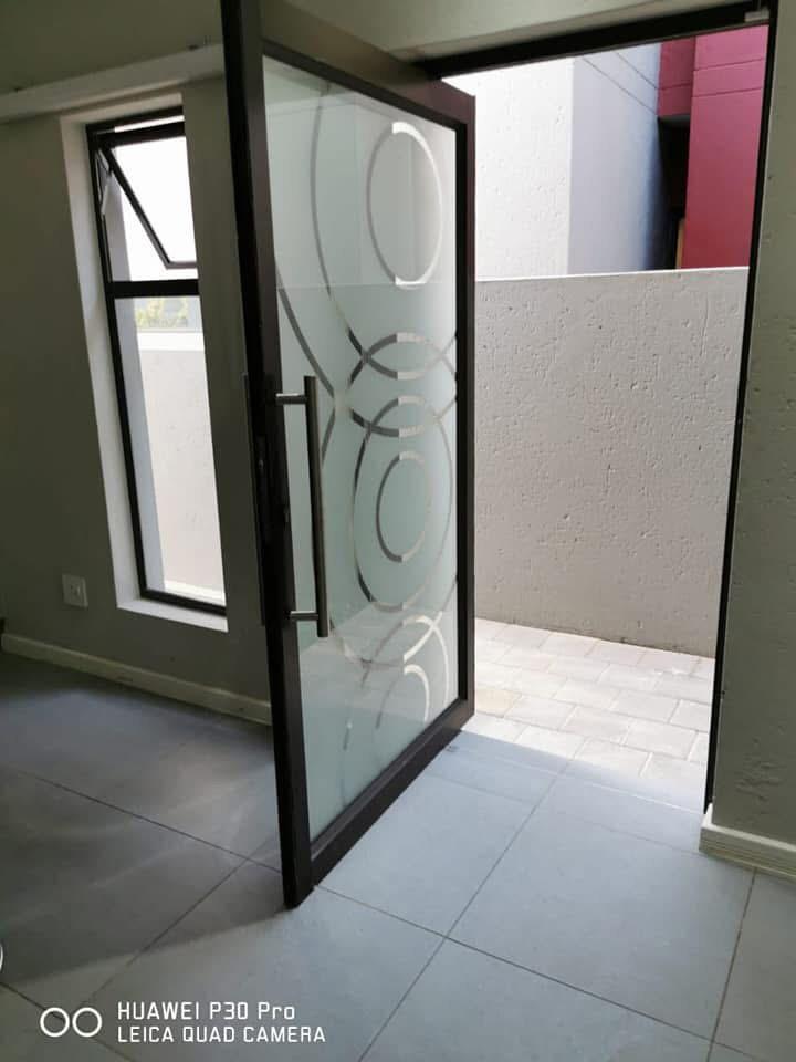 Aluminium-framed glass door with a sandblasted circle motif