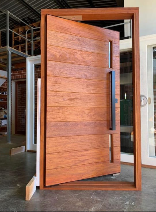 An oversized custom timber pivot door in the Hybrid Carpentry workshop